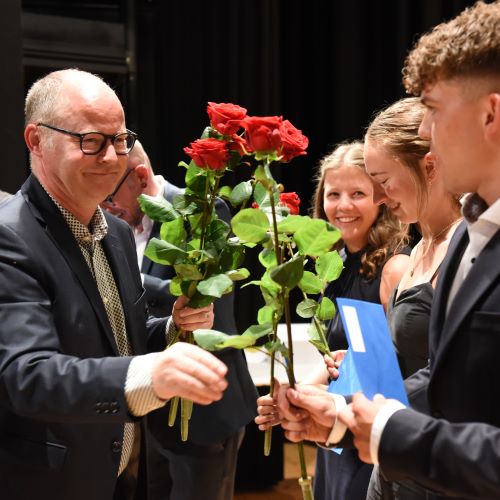 Martin Bisig, Rektor der Kantonsschule Willisau, gratuliert den Maturandinnen und Maturanden mit einer Rose zur Maturität.